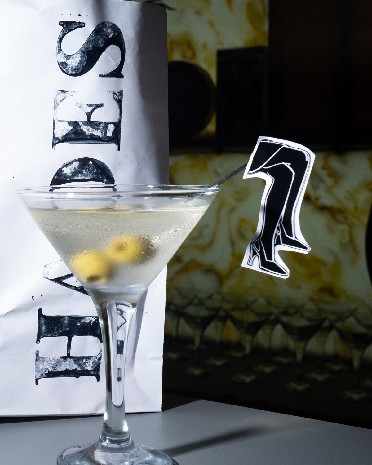 An image of a cocktail and HADES stamped popcorn bag