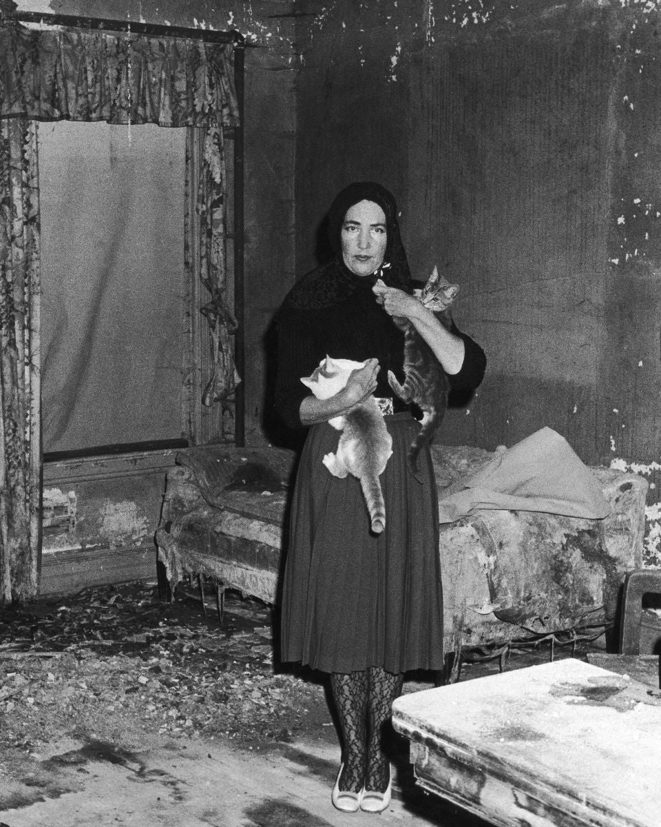 A black and white image of Little Edie in her home