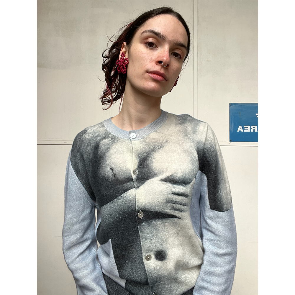 Person wearing a sweater with a graphic design of a torso.