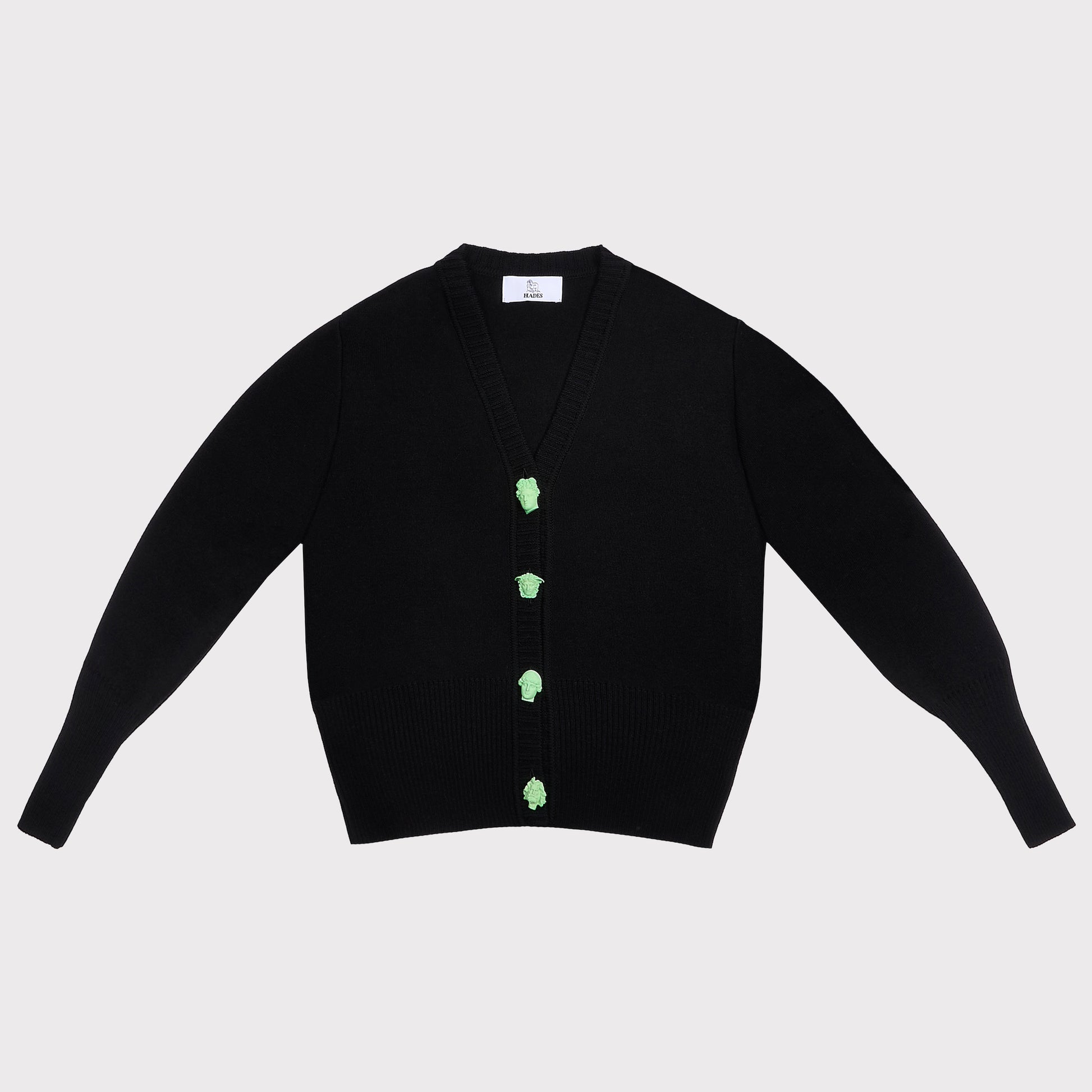 A black knit cardigan sweater with long sleeves featuring four light green decorative Greek Mythology buttons down the front, laid flat against a light gray background.