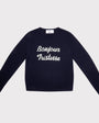 A navy blue long-sleeve crewneck sweatshirt with 'Bonjour Tristesse' printed in white script across the chest, displayed flat against a light gray background.