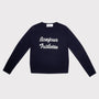 A navy blue long-sleeve crewneck sweatshirt with 'Bonjour Tristesse' printed in white script across the chest, displayed flat against a light gray background.