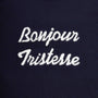 A close up image of  'Bonjour Tristesse' printed in white script.