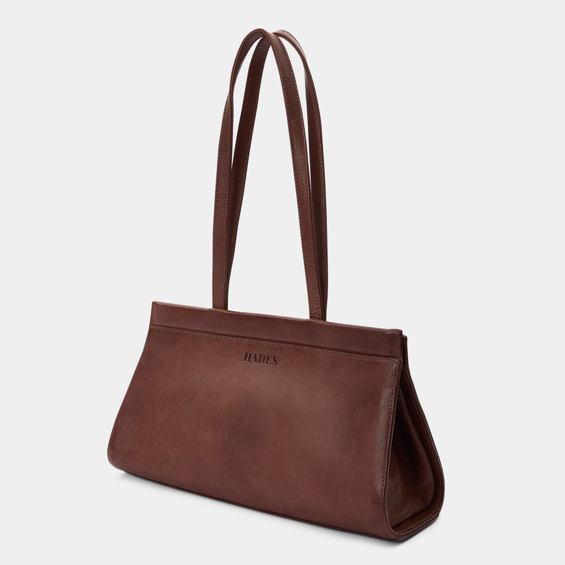 A dark brown leather shoulder bag with long double straps and the brand name 'HADES' embossed on the front, shown against a light gray background.