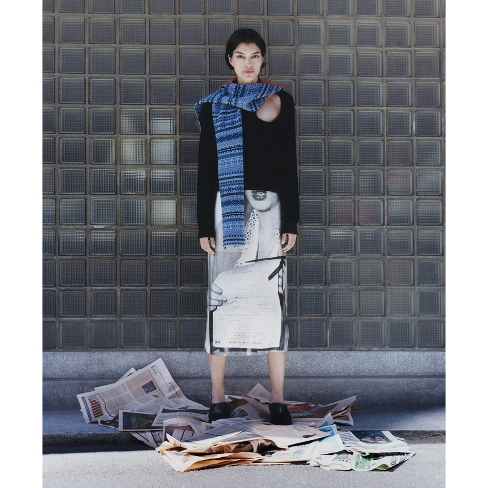 Image of a model wearing the Fair Isle Burnt Organge & Blue Hooded scarf and the HADES Selavy Black Knit and the HADES Ordinary Happiness skirt.