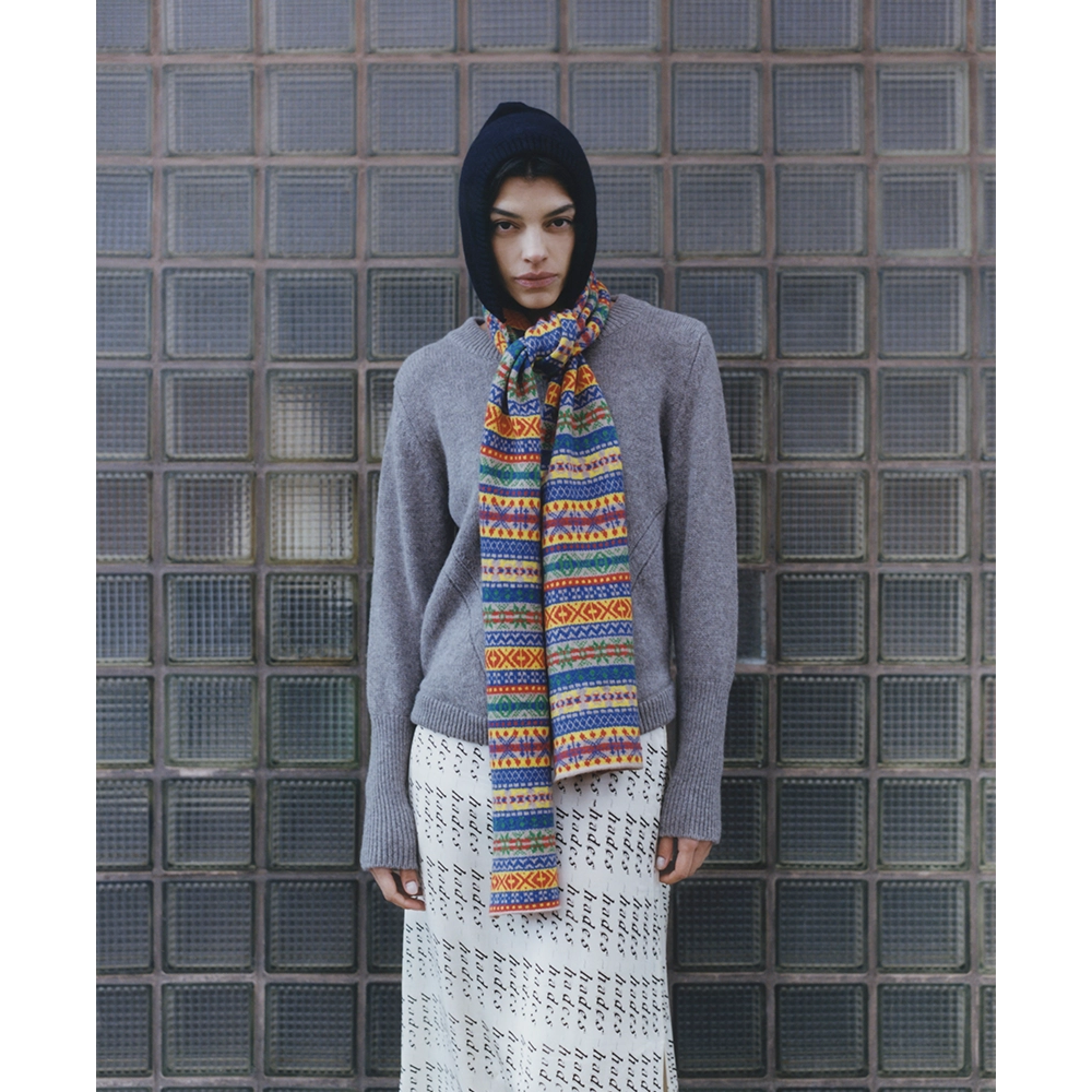 Image of a model wearing the Fair Isle Navy & Multi-Coloured Hooded scarf, the HADES Armour Knit, and the HADES HADES HADES skirt.