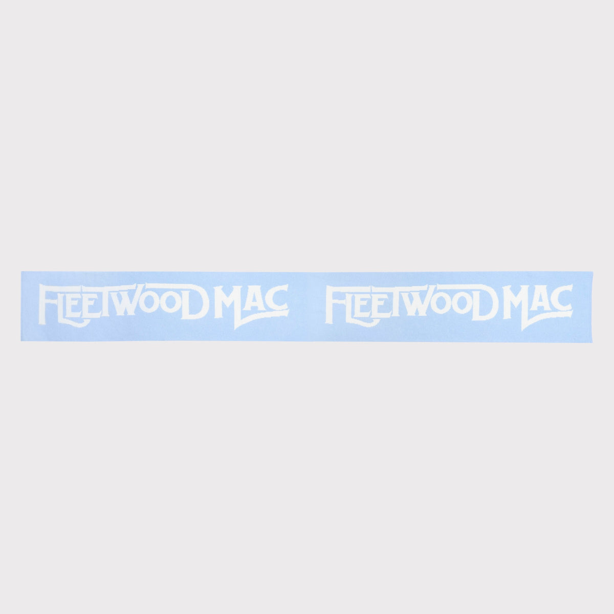 A light blue knit scarf with 'Fleetwood Mac' knitted across. The scarf is shown laid flat a solid light grey background.