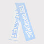 A light blue knit scarf with 'Fleetwood Mac' knitted across. The scarf is shown folded against a solid light grey background.