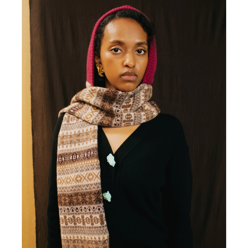 Image of a model wearing the Fair Isle Berry & BrownHooded scarf and the HADES Greek Mythology Knit.