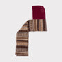An image of The Berry & Brown Fair Isle hooded scarf laid flat on a light grey background. 