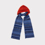 An image of The Burnt Orange & Blue Fair Isle hooded scarf tied in a knot on a light grey background. 