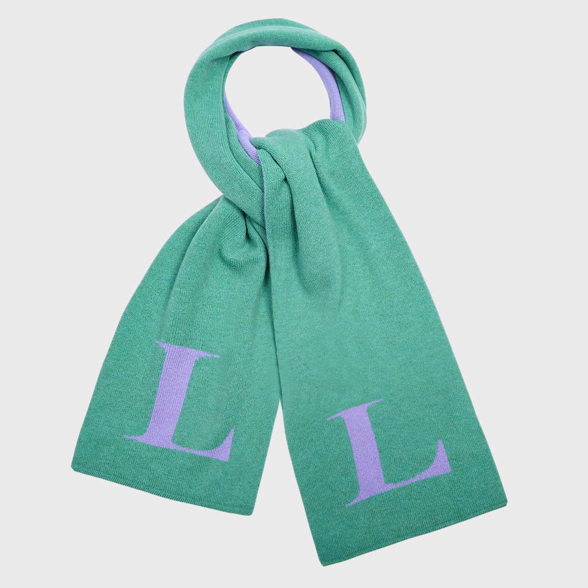 A mint green knit scarf with a large lavender letter 'L' on each end, shown against a light grey background.