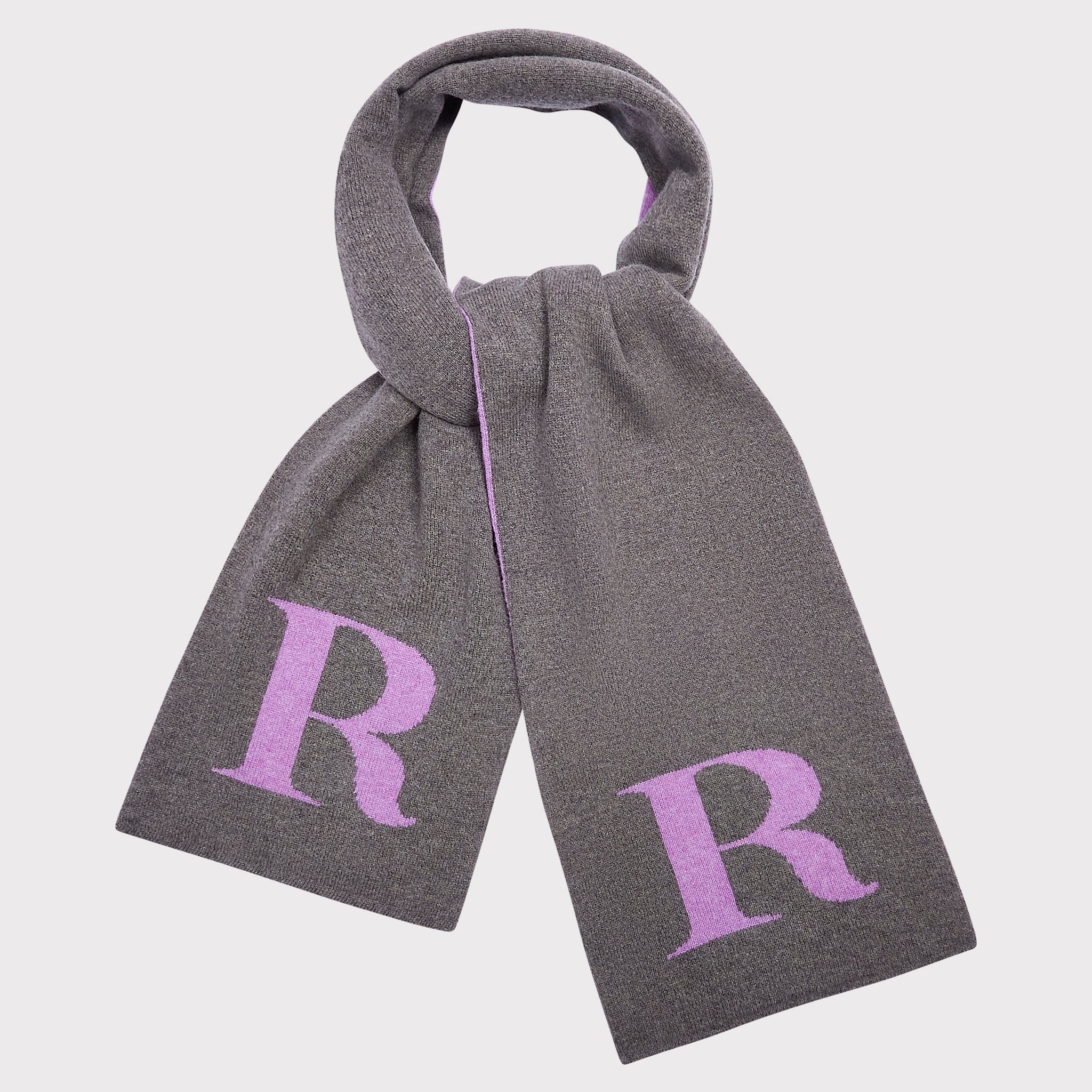 A grey knit scarf with a loop at the top, featuring a large lavender letter 'R' on each end, shown against a light grey background.