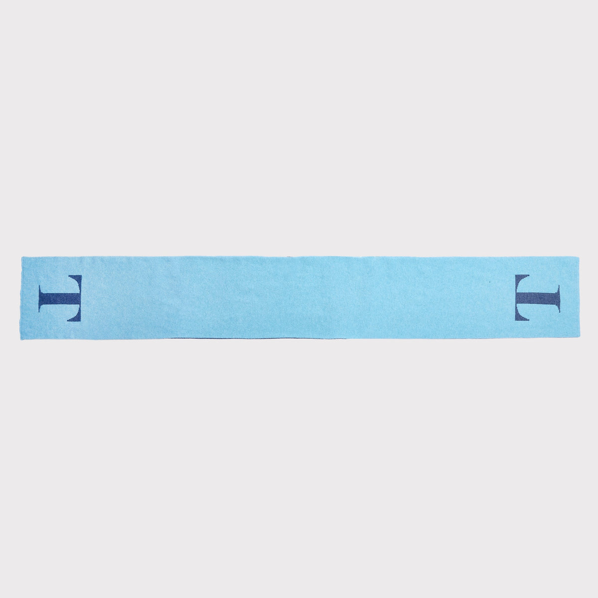A light blue scarf laid flat with a dark navy blue letter 'T' printed on each end, shown against a plain light grey background.