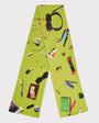 An image the HADES Handbag lime green knit scarf featuring the contents of a handbag such as pink lipstick, a banana, a hair clip, a purple compact, and a black pen.