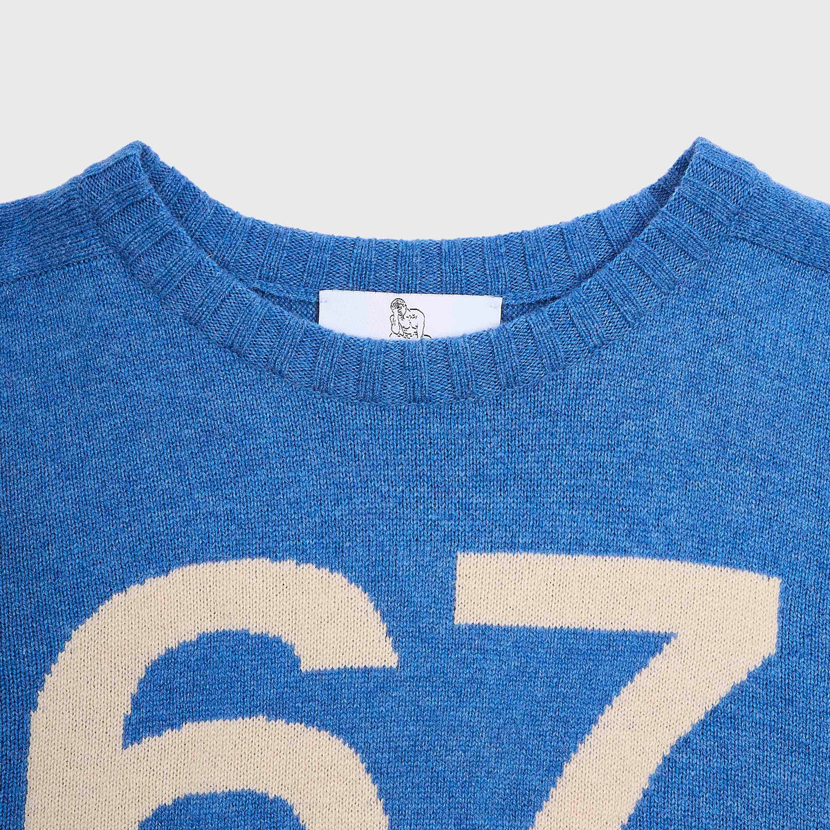 Close-up of the 1967 blue Fleetwood Mac knit with a cream-coloured number 67.