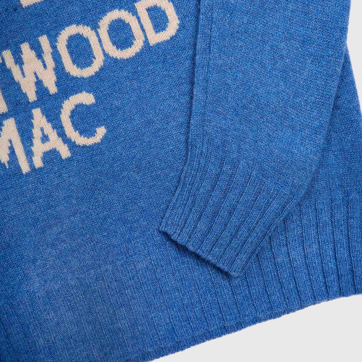 Close-up the 1967 Fleetwood Mac blue knit with cream-coloured lettering reading and ribbed cuffs and hem.