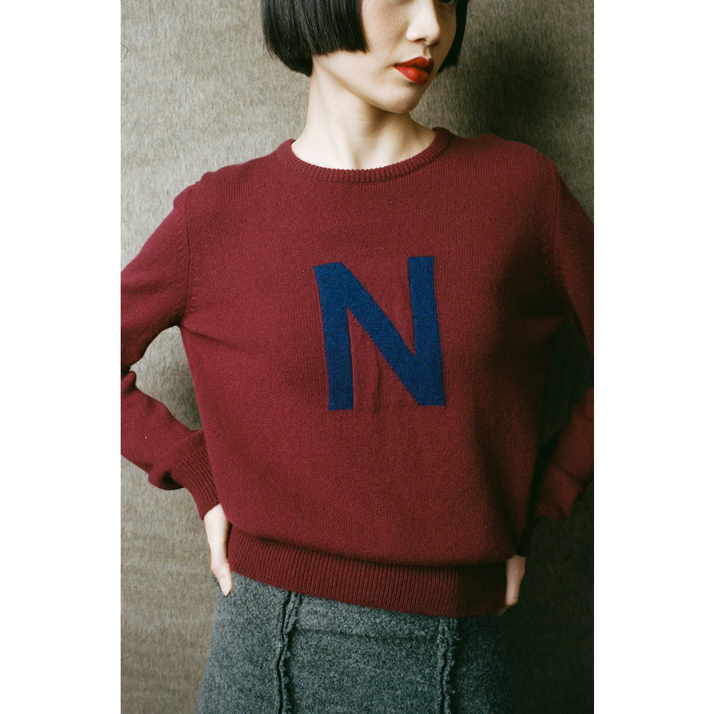 Person wearing a maroon sweater with a blue 'N' 