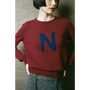 Person wearing a maroon sweater with a blue 'N' 