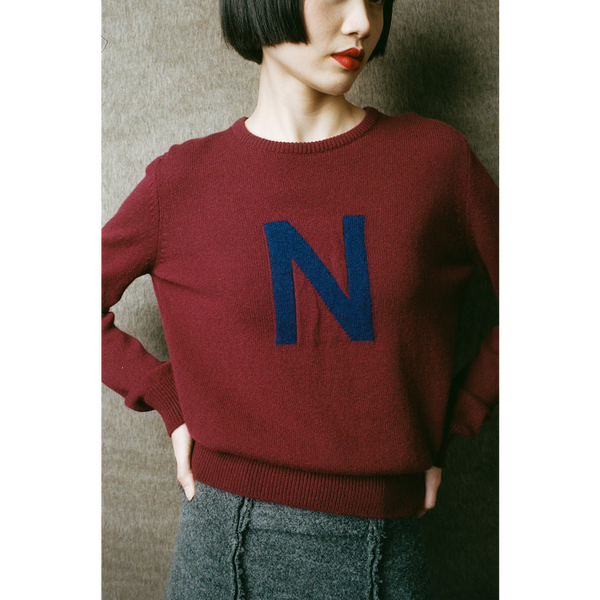 Person wearing a maroon sweater with a blue 'N' 