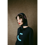 Person wearing HADES Navy blue knit  with a turquoise letter 'C' 
