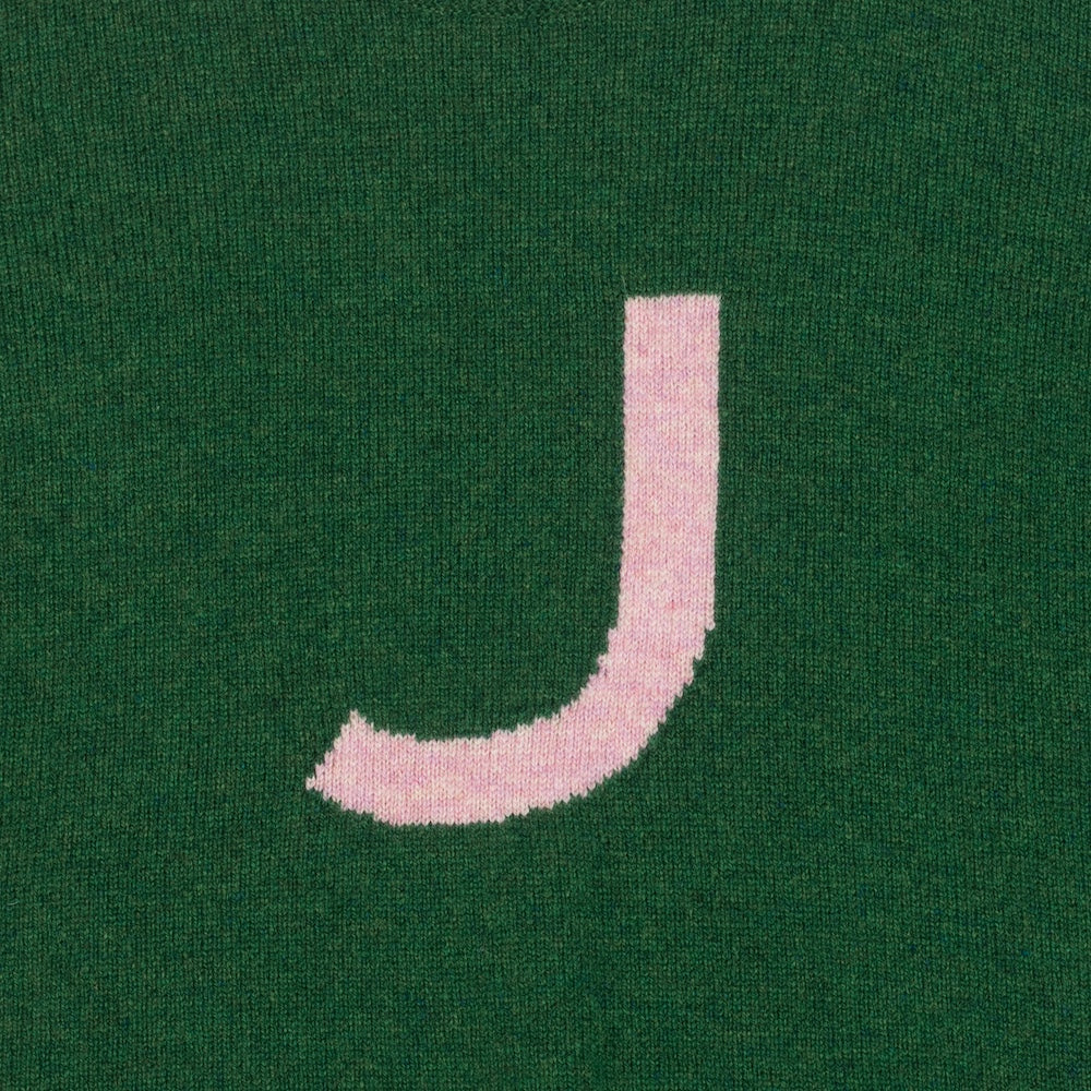 HADES green jumper with a pink letter 'J'  detail