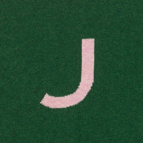 HADES green jumper with a pink letter 'J'  detail