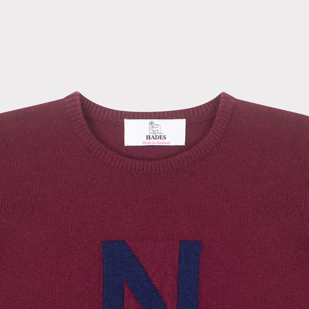 HADES burgundy jumper with a blue letter 'N' necklabel