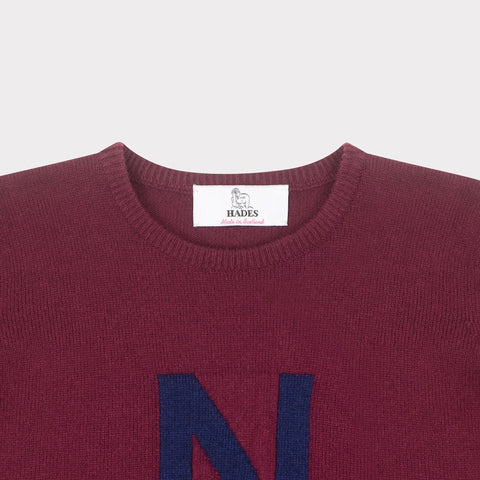 HADES burgundy jumper with a blue letter 'N' necklabel