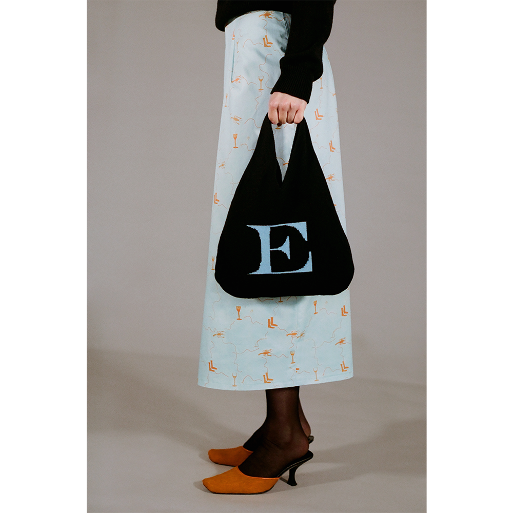 Model holding the HADES wool Letter E bag