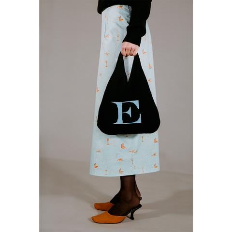 Model holding the HADES wool Letter E bag