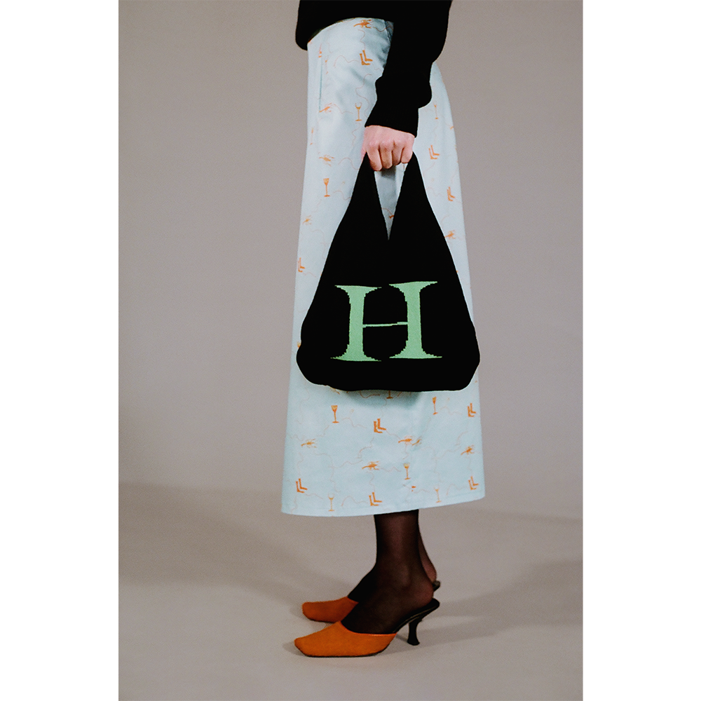 Model holding the HADES wool Letter H bag