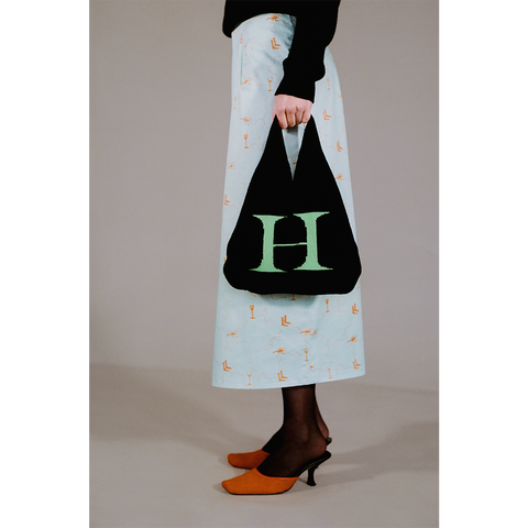 Model holding the HADES wool Letter H bag