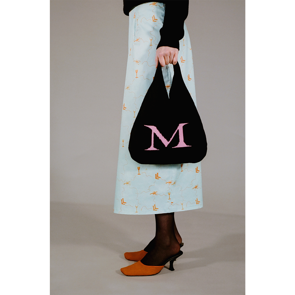 Model holding the HADES wool Letter M bag