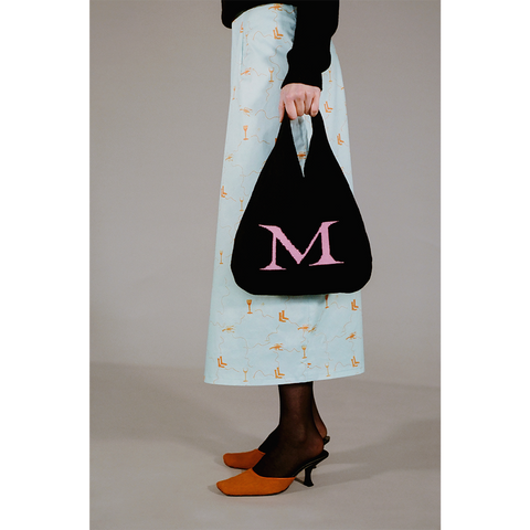 Model holding the HADES wool Letter M bag