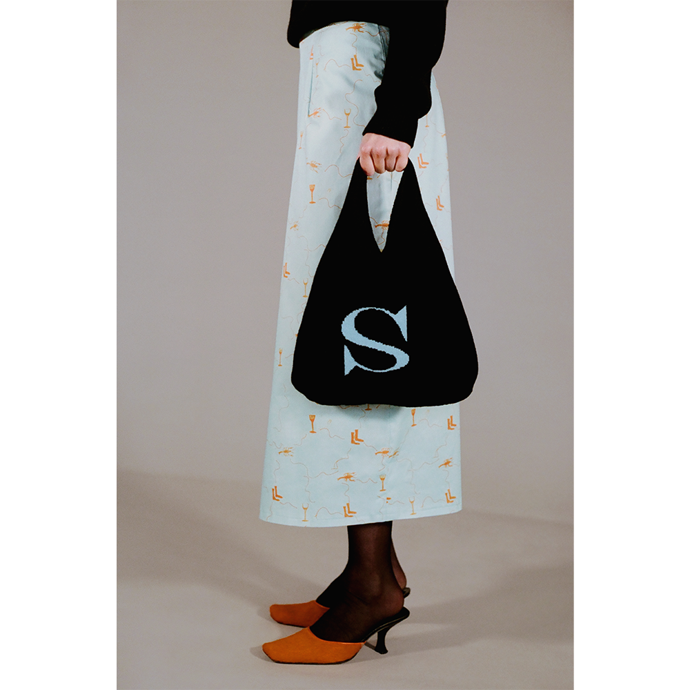 Model holding the HADES wool Letter S bag