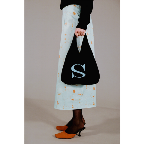 Model holding the HADES wool Letter S bag