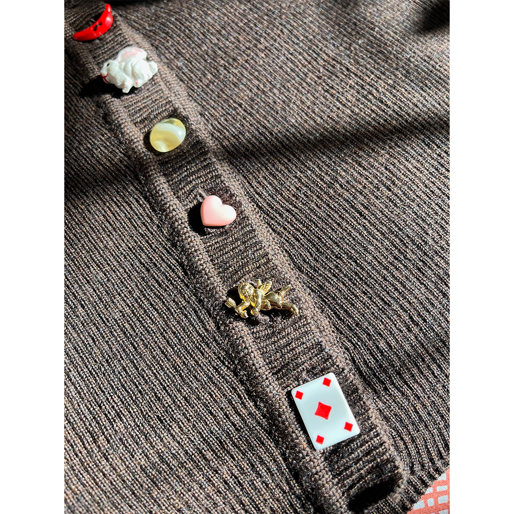 Close-up of a wool cardigan with colorful buttons on a white background