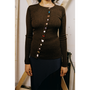 Model wearing a brown HADES cardigan with colorful fun buttons