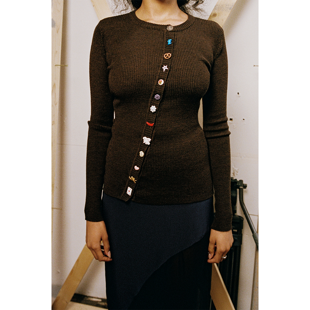 Model wearing a brown HADES cardigan with colorful fun buttons