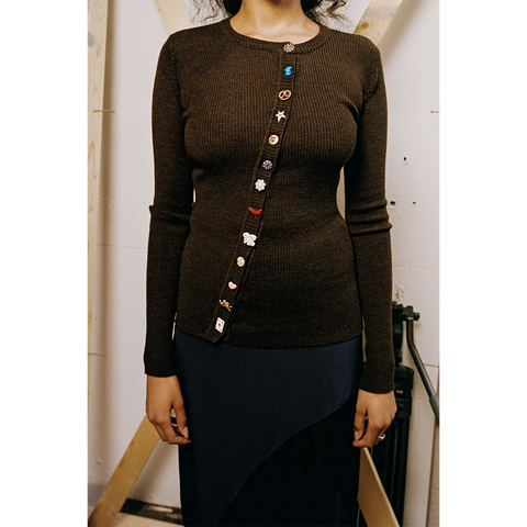Model wearing a brown HADES cardigan with colorful fun buttons