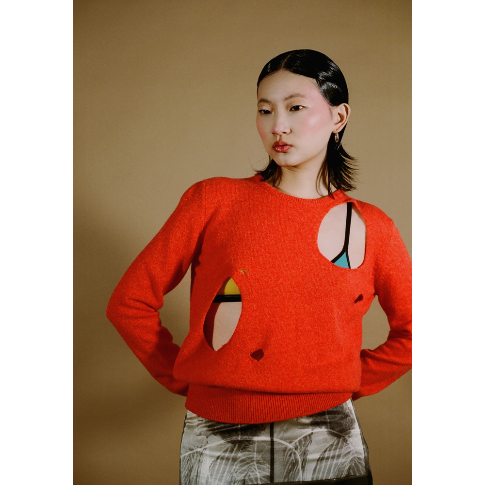 Upclose shot of the orange Selavy jumper from the DADA Collection