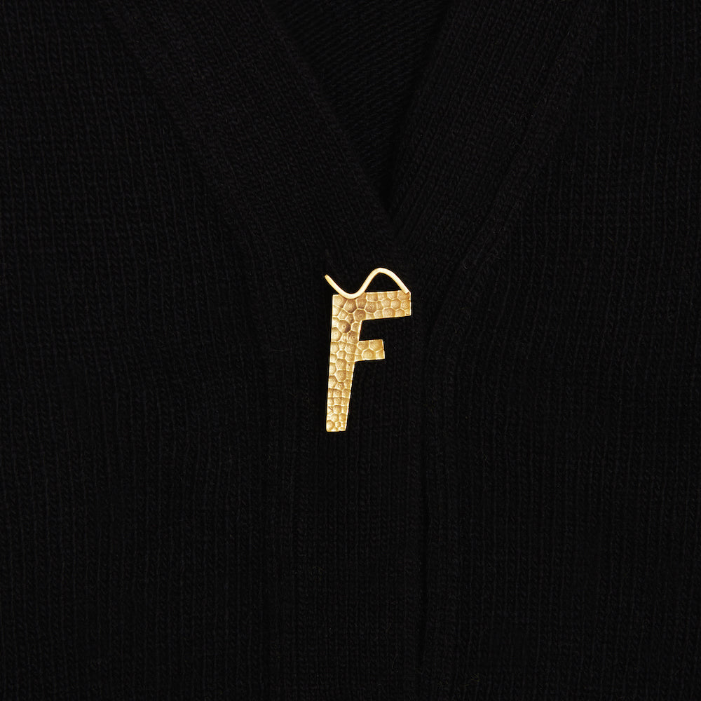 Up close shot of the F gold plated button featured on the FU*K Carrington cardigan