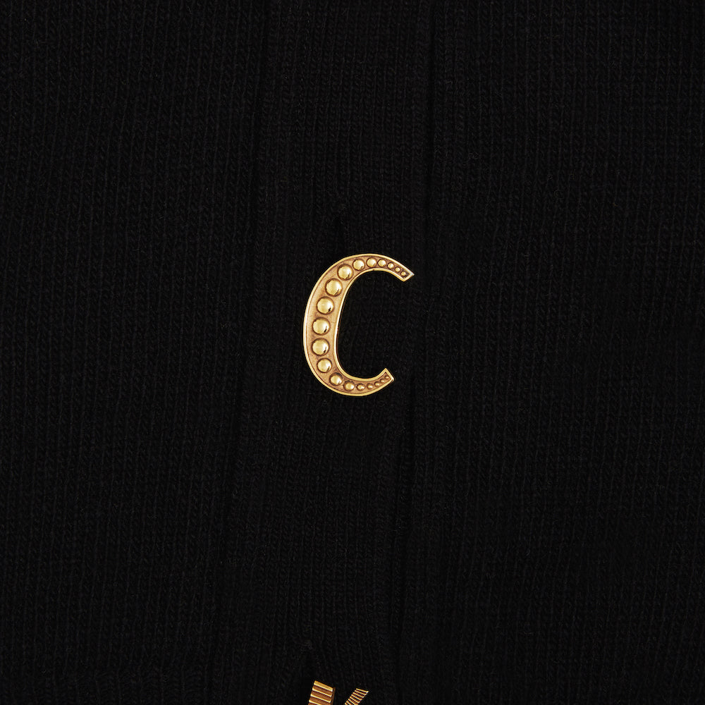 Up close shot of the C gold plated button featured on the FU*K Carrington cardigan