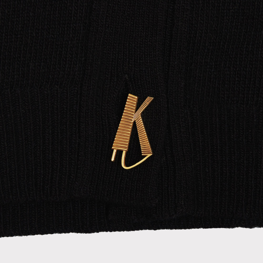 Up close shot of the K gold plated button featured on the FU*K Carrington cardigan