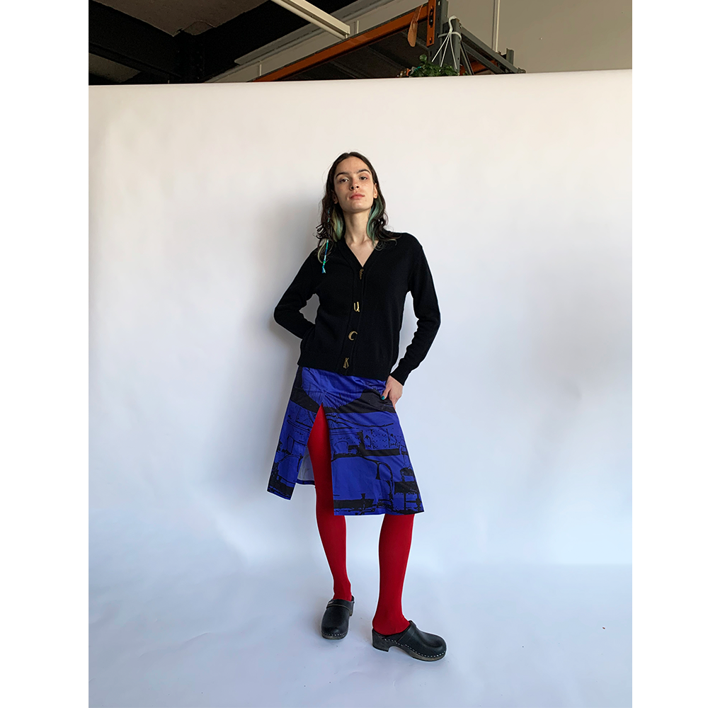 Model wearing the black carrington cardigan with gold plated letters spelling FU*K styled with the 'No Exit' skirt and the pink hooded scarf