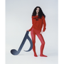 A model wearing the red Fleetwood Mac knit jumper, shown against a plain light background whilst holding a handmade black music note.
