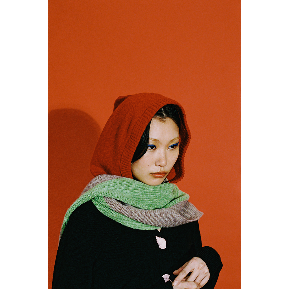 Model in HADES red hooded scarf