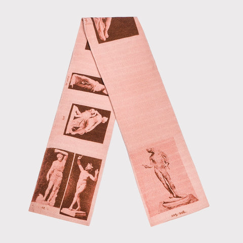 Pink scarf with vintage-style prints of statues and figures on a light pink background