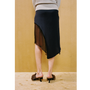 Close up of a lady wearing the Delusion skirt against a wooden backdrop